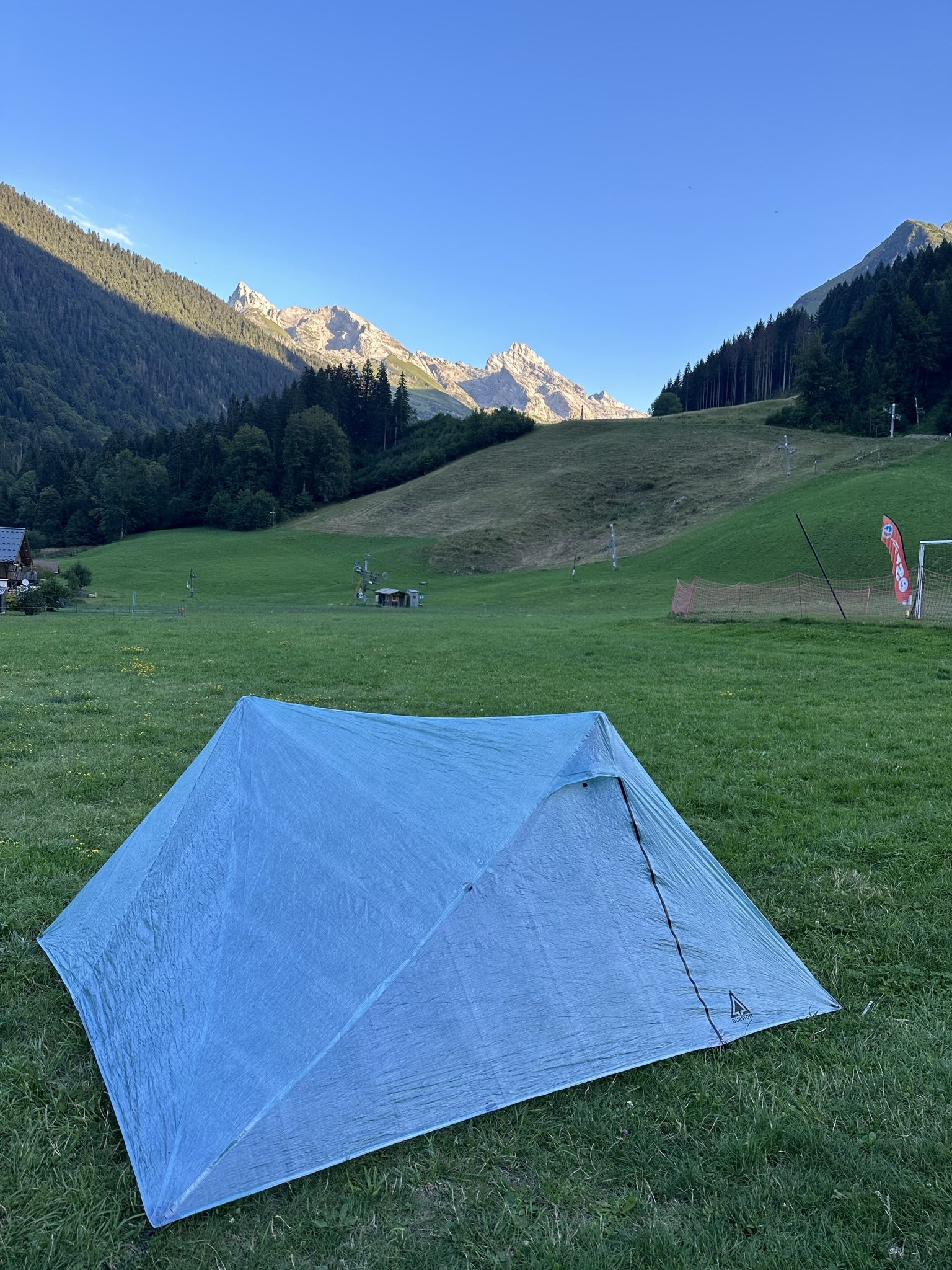 Tente ultralégère en bivouac au coucher du soleil dans les Alpes