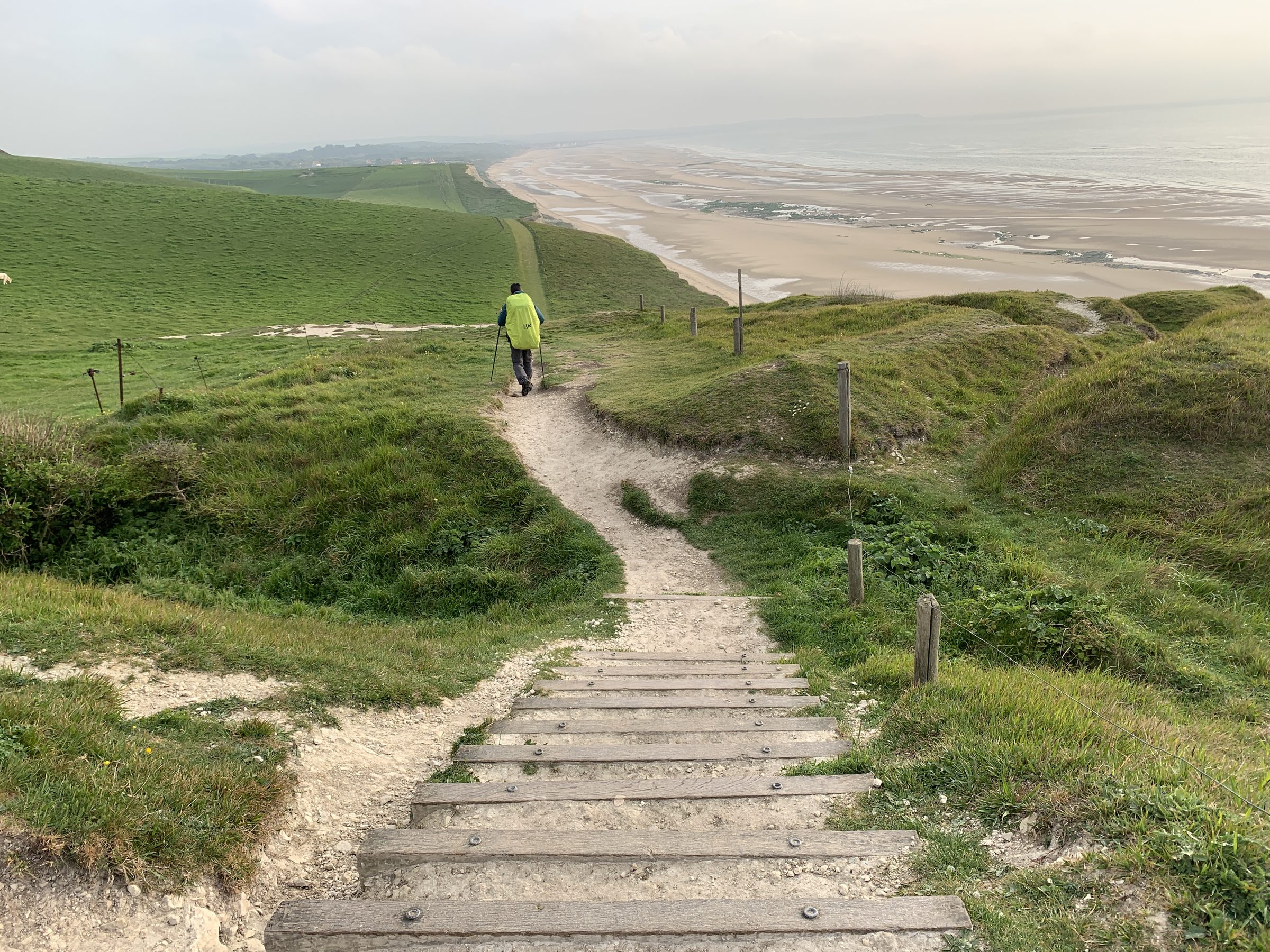 Randonneur dans un escalier de falaise surplombant la plage